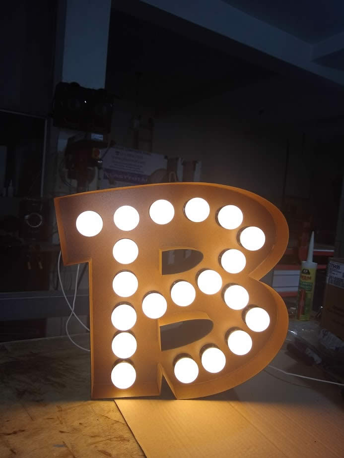 Letras caixa com pintura aço corten e iluminação com lâmpadas bolinhas